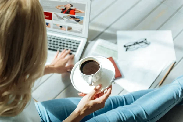 Womans ręce trzymając kubek kawy i laptopa — Zdjęcie stockowe