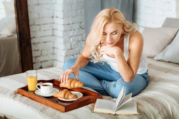 Kobieta czytająca dokonać rezerwacji i jeść — Zdjęcie stockowe