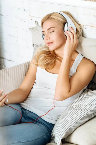 Женщина слушает музыку в постели — стоковое фото