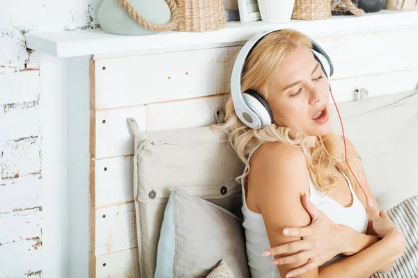 Женщина слушает музыку в постели — стоковое фото