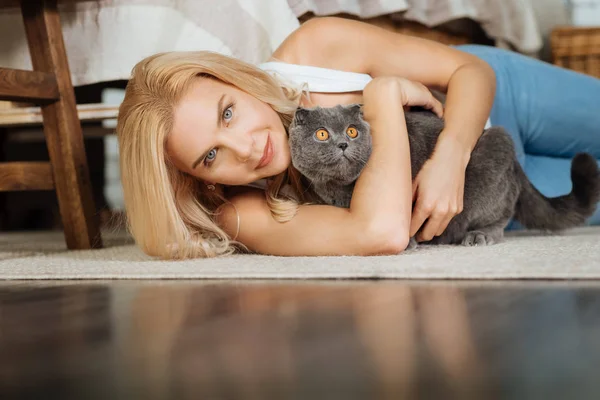 Kadın onu kedi ile yerde yatarken — Stok fotoğraf