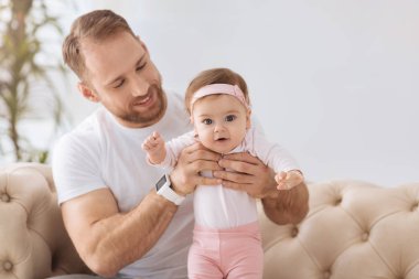 Mutlu genç adam onun bebekle oynarken