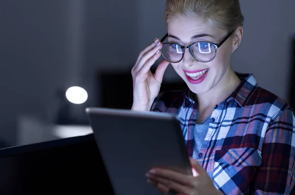 Sorrindo IT menina testando gadget no quarto iluminado escuro — Fotografia de Stock