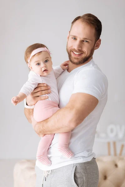 Щасливий молодий батько обіймає свою маленьку дівчинку вдома — стокове фото