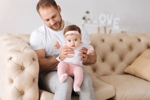 Konzentrierter junger Mann zieht sein Kleinkind groß — Stockfoto