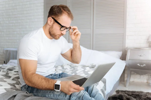 Diligent young man using laptop and working at home — Stock Photo, Image