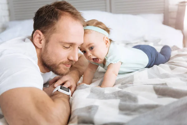 침실에서 그녀의 아버지와 함께 휴식 하는 호기심 어린 딸 — 스톡 사진