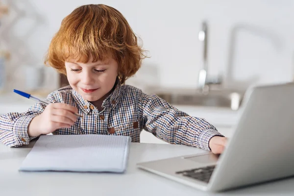 Světlé inteligentní dítě dělá svůj domácí úkol — Stock fotografie