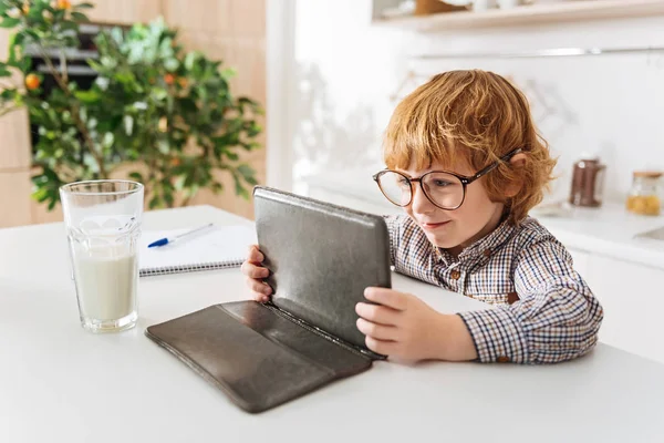 Entzückendes Kind liest etwas auf seinem Tablet — Stockfoto