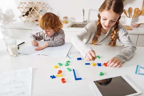 Menina admirável explicando matemática para seu irmão — Fotografia de Stock