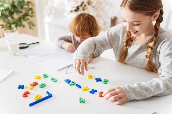 Enthusiastic helping sister arranging formulas — Stock Photo, Image