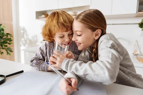 Animados hermanos admirables compartiendo una bebida —  Fotos de Stock