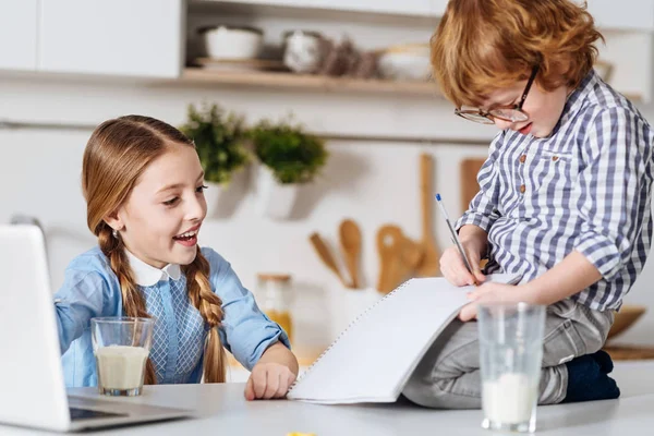 Estudiante atento anotando las palabras de sus hermanas — Foto de Stock