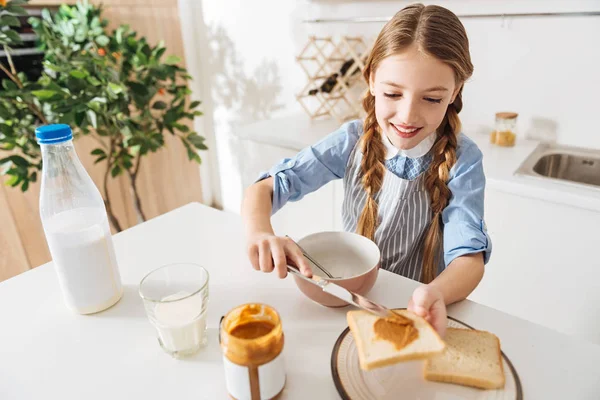 Fröhliches nettes Kind macht Erdnussbutter-Sandwiches — Stockfoto