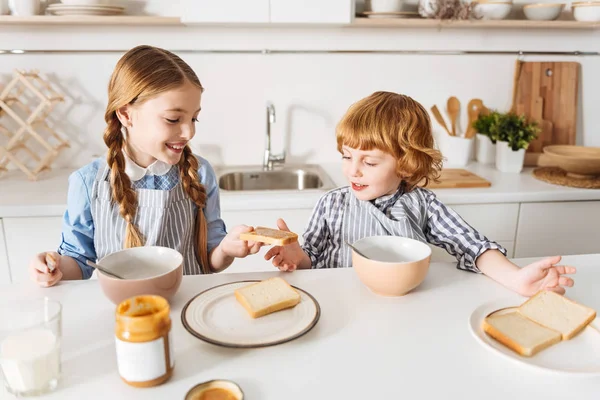 Schöne Geschwister teilen frisch gebackene Sandwiches — Stockfoto