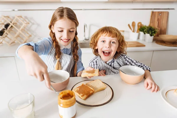 Nette, energische Kinder genießen ihre morgendliche Mahlzeit — Stockfoto