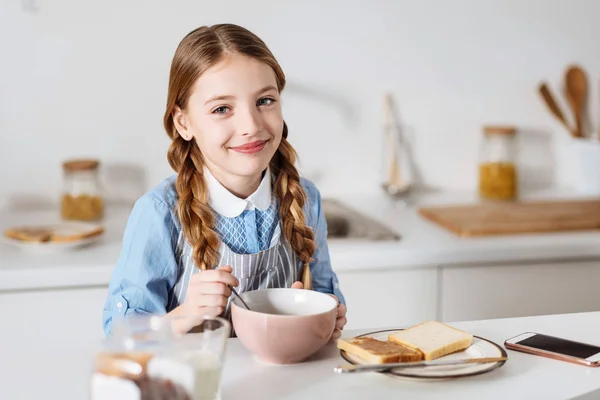 Schönes Mädchen sieht beim Frühstück begeistert aus — Stockfoto