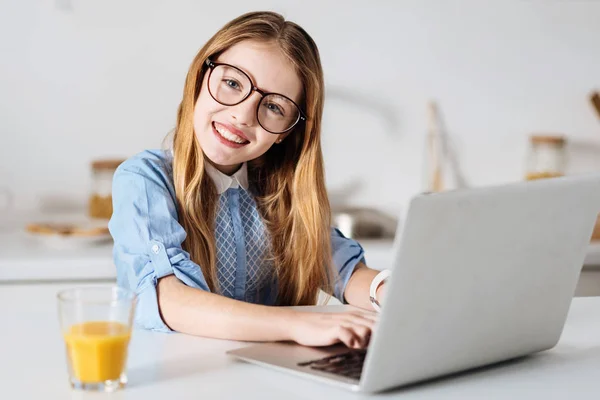 Entusiasta chica brillante escribiendo en su computadora portátil — Foto de Stock