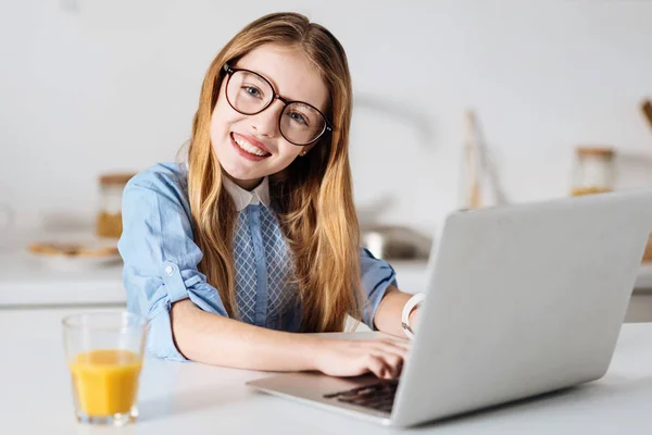 Entusiástico menina brilhante digitando em seu laptop — Fotografia de Stock