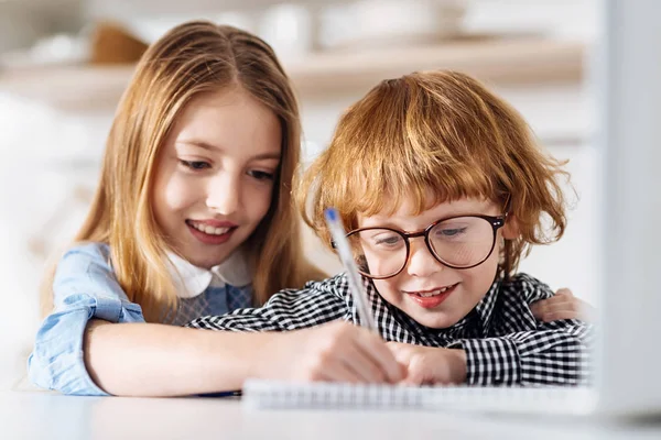 Krásná potvrzené dívka učí její bratr psát — Stock fotografie