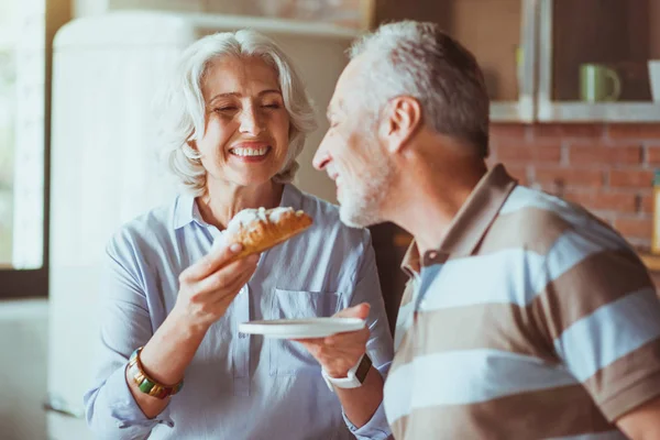 Frau schenkt ihrem Mann Croissant — Stockfoto