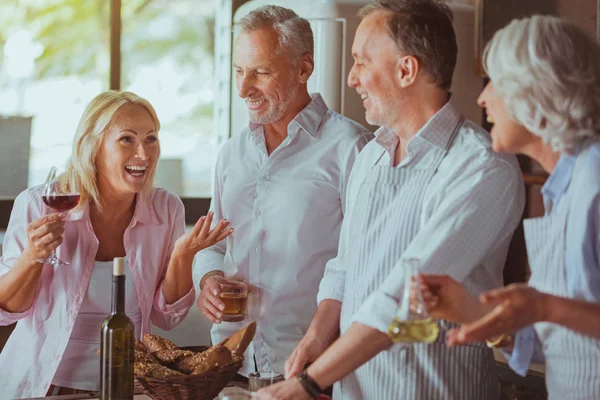 Positive alte Freunde bereiten sich auf festliches Abendessen vor — Stockfoto