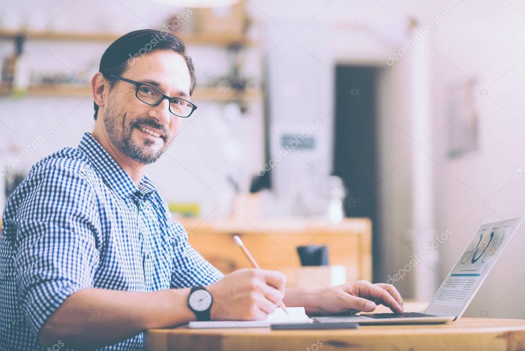 Positive adult man sitting in the cafe