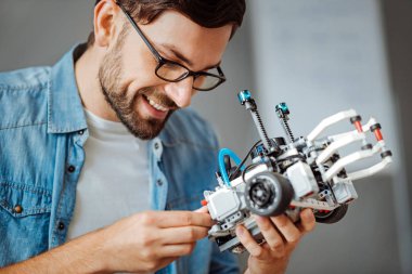 Smiling professional engineer holding robot clipart