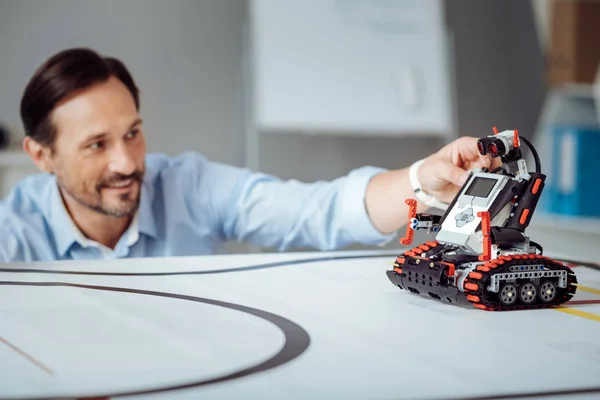 Positive professional engineer testing the robot — Stock Photo, Image