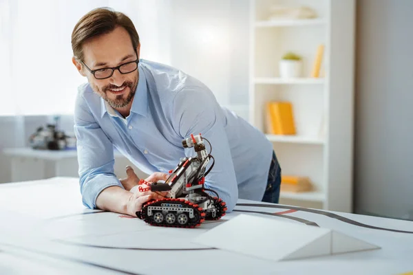 Possitive professional engineer testing robot in a lab — Stock Photo, Image