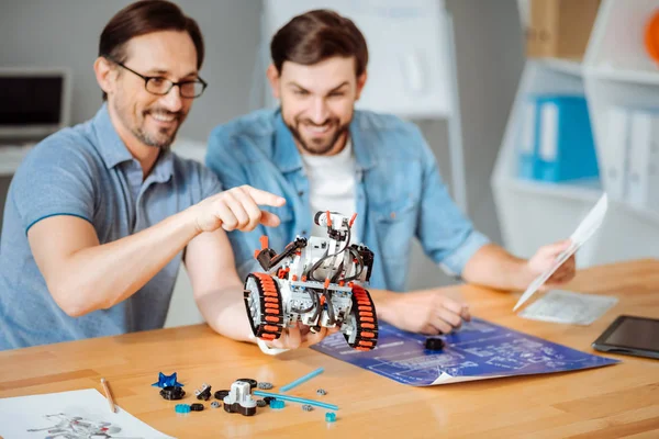 Engenheiros positivos examinando o robô — Fotografia de Stock