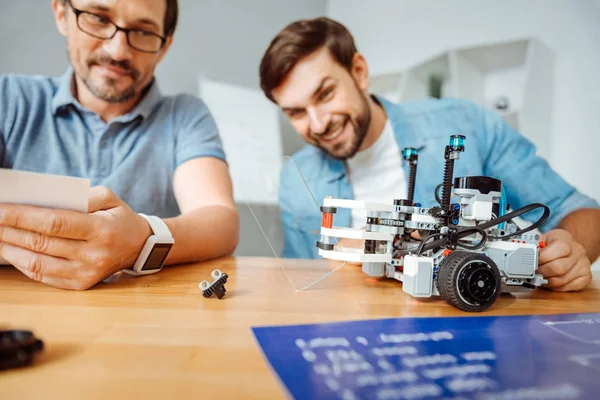 Engenheiros positivos testando o robô — Fotografia de Stock