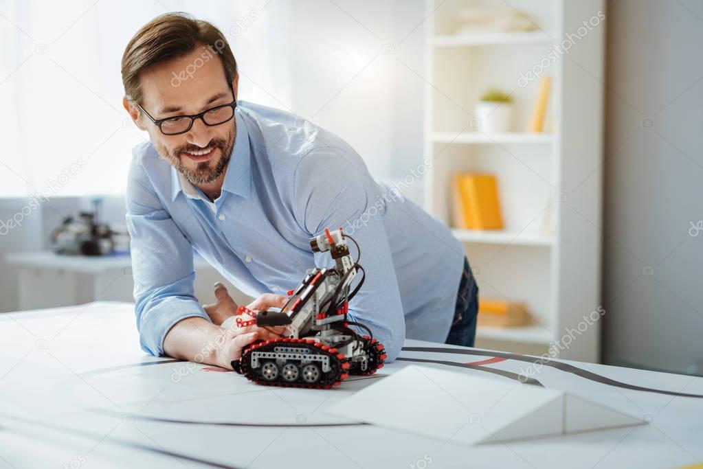 Possitive professional engineer testing robot in a lab