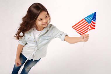 Neşeli kız stüdyoda Amerikan bayrağı ile oynarken
