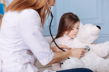 Profesyonel doktor küçük grl kabarık oyuncak incelenmesi