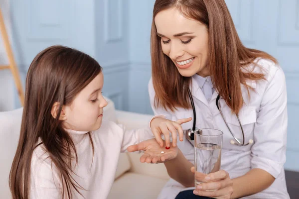 Alegre médico dando pastillas a la niña —  Fotos de Stock