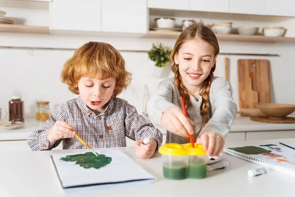 Chica entreteniendo a su hermano pequeño — Foto de Stock