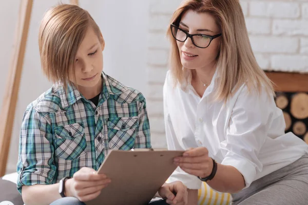 Positieve expert zitten in de buurt van jonge patiënt — Stockfoto