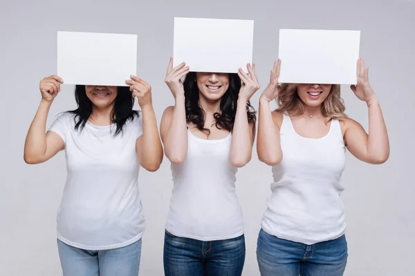 Damer visar vita bitar av papper — Stockfoto