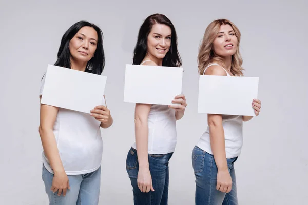 Mulheres mostrando pedaços de papel branco — Fotografia de Stock