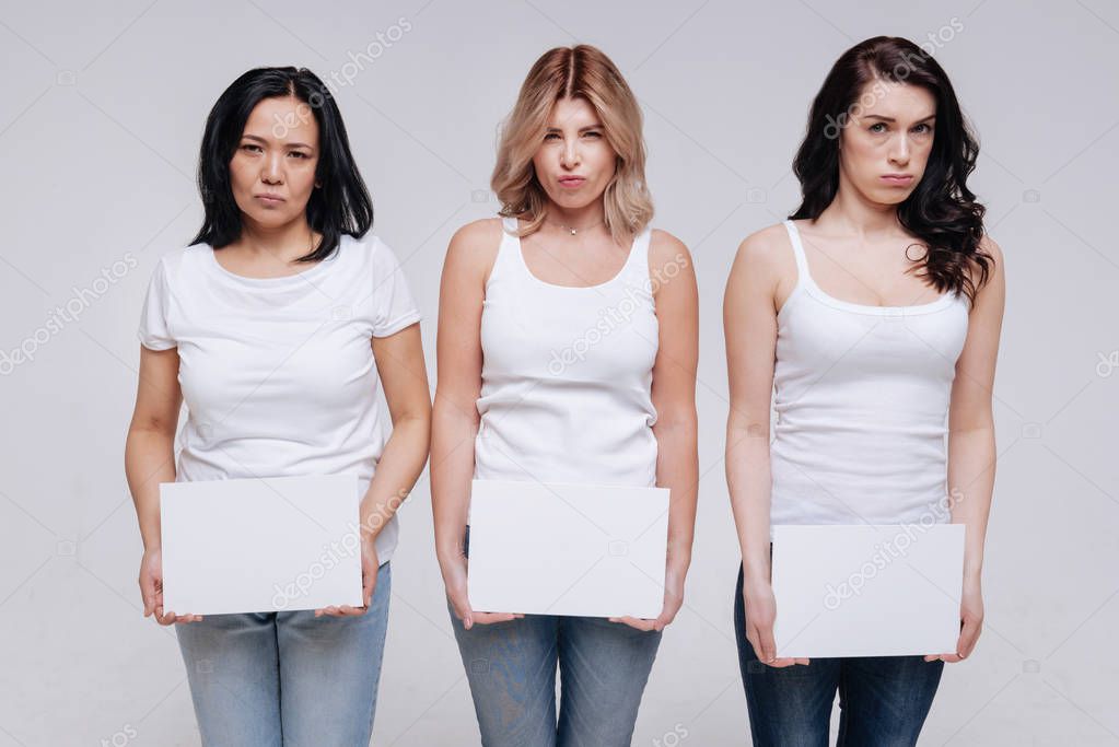 Artistic  ladies  holding white pieces of paper