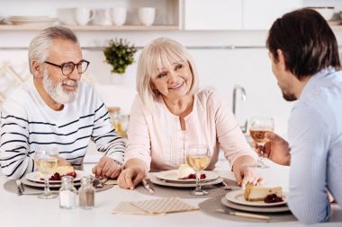 Neşeli aile yemek masasında oturan