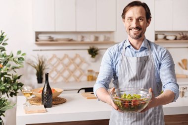 Salata bir kase tutarak memnun adam 