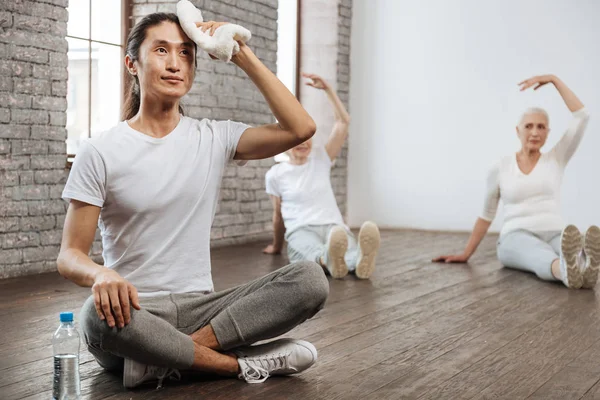 Asiatische Tutor sitzt in Yoga-Pose auf dem Boden — Stockfoto