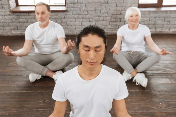 Пенсионеры с инструктором по йоге — стоковое фото