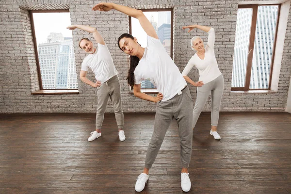 Three active people stooping their bodies — Stock Photo, Image