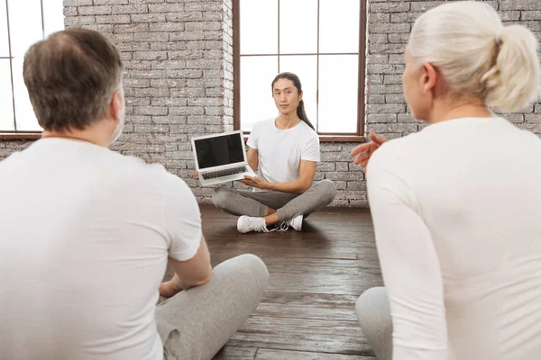 Ernsthafte Yoga-Couch mit Laptop in beiden Händen — Stockfoto