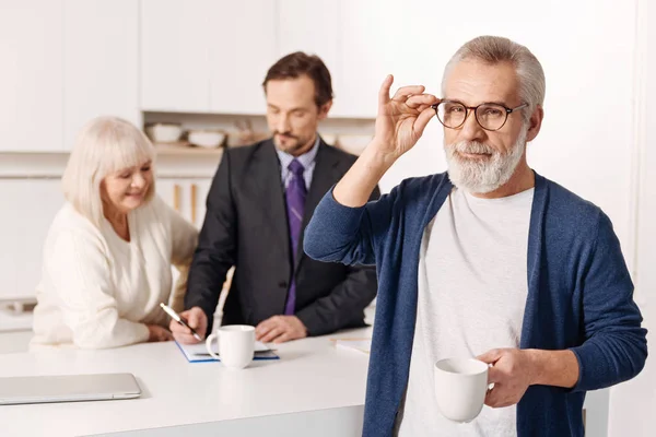 Hombre relajándose mientras su esposa firma el contacto — Foto de Stock