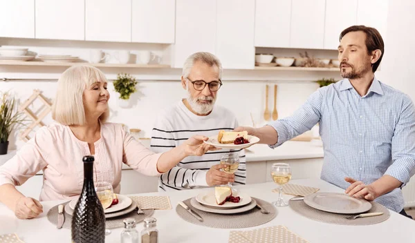 Χαρισματικός άνθρωπος απολαμβάνει οικογενειακό δείπνο με τους γονείς στο σπίτι — Φωτογραφία Αρχείου