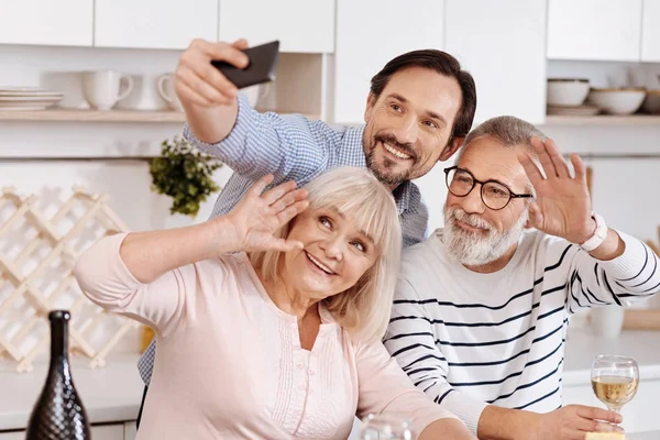 Uomo sorridente scattare selfie con i genitori anziani — Foto Stock